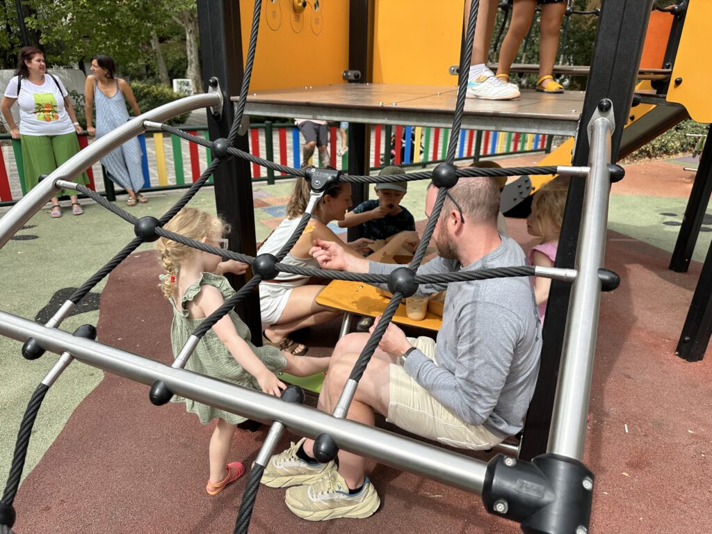 The girls playing with dad on the playground